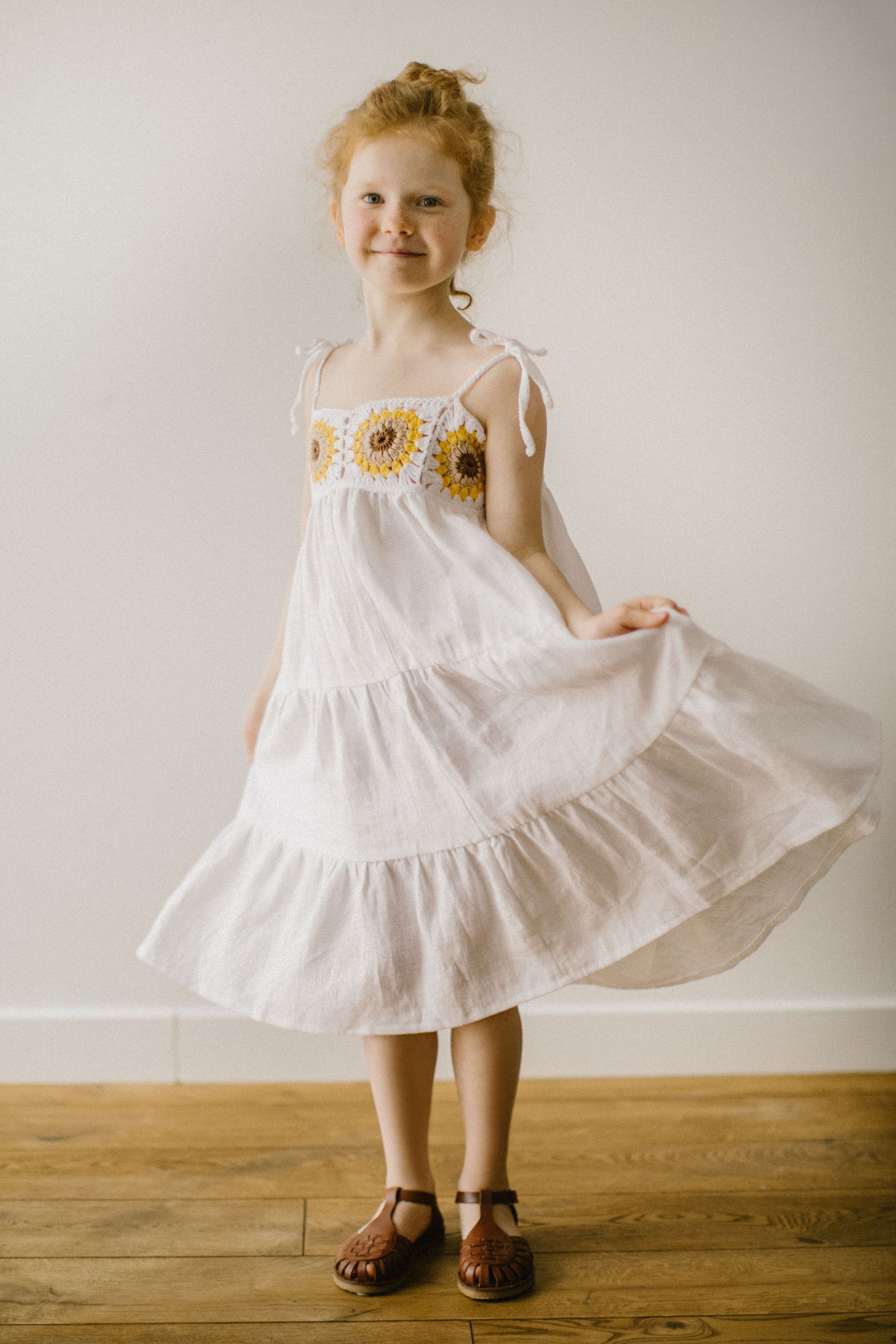 Beautiful girl's white linen dress with crochet sunflowers