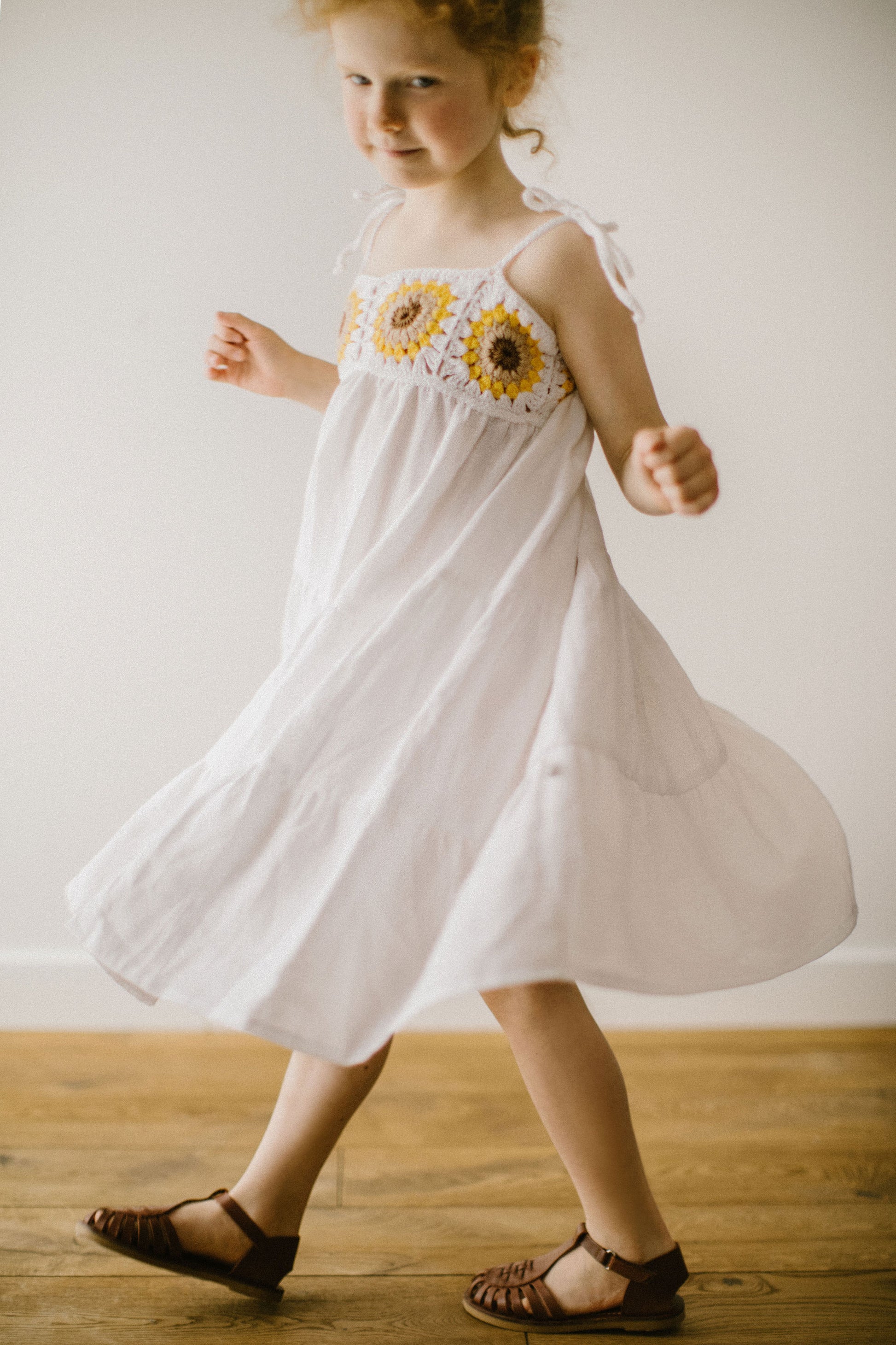 Beautiful girl's white linen dress with crochet sunflowers