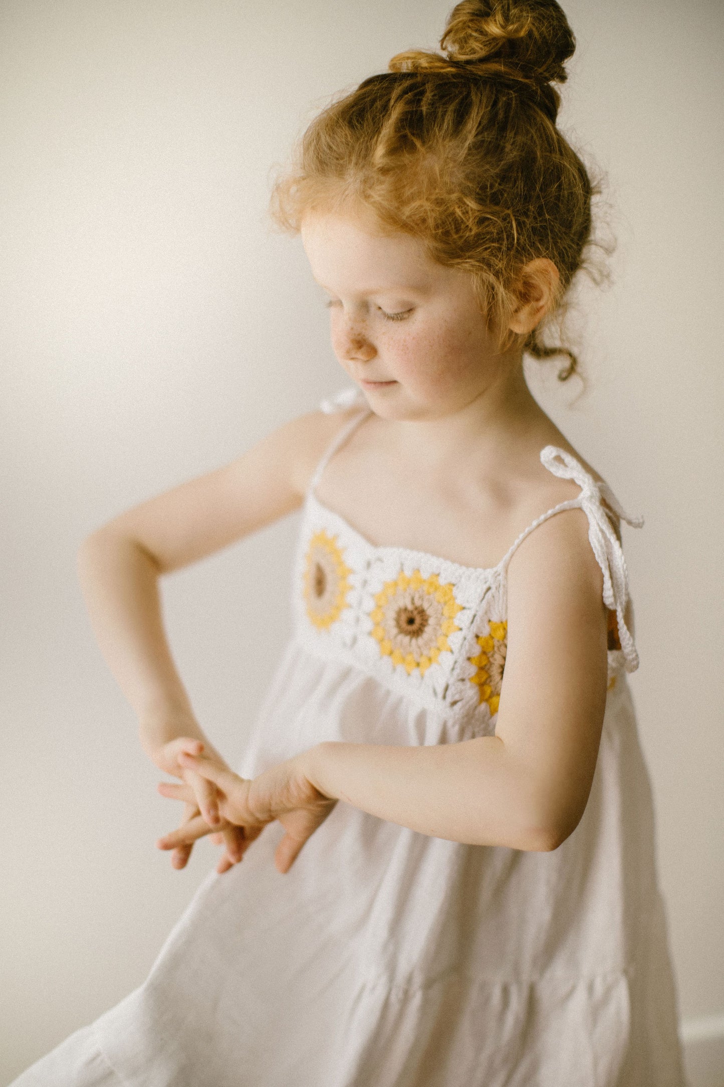 Beautiful girl's white linen dress with crochet sunflowers