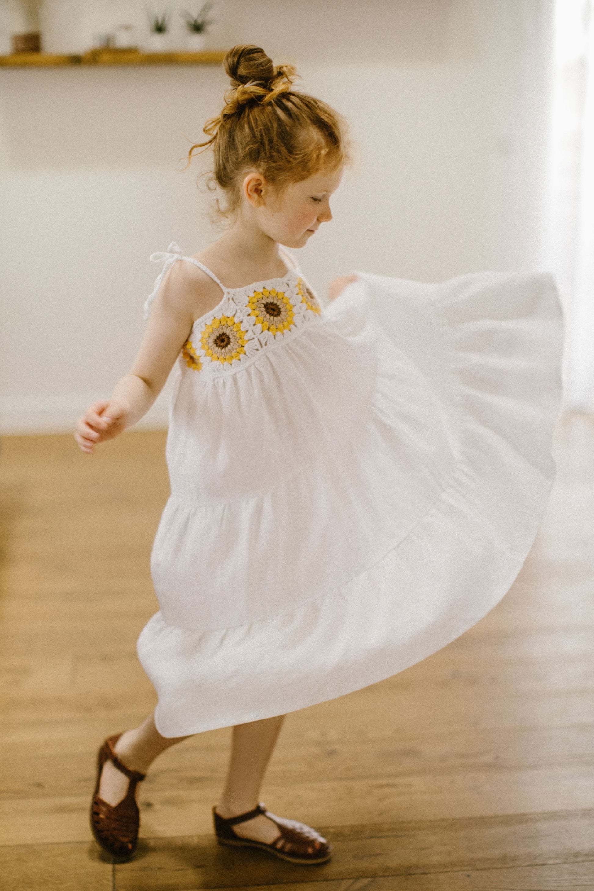 Beautiful girl's white linen dress with crochet sunflowers